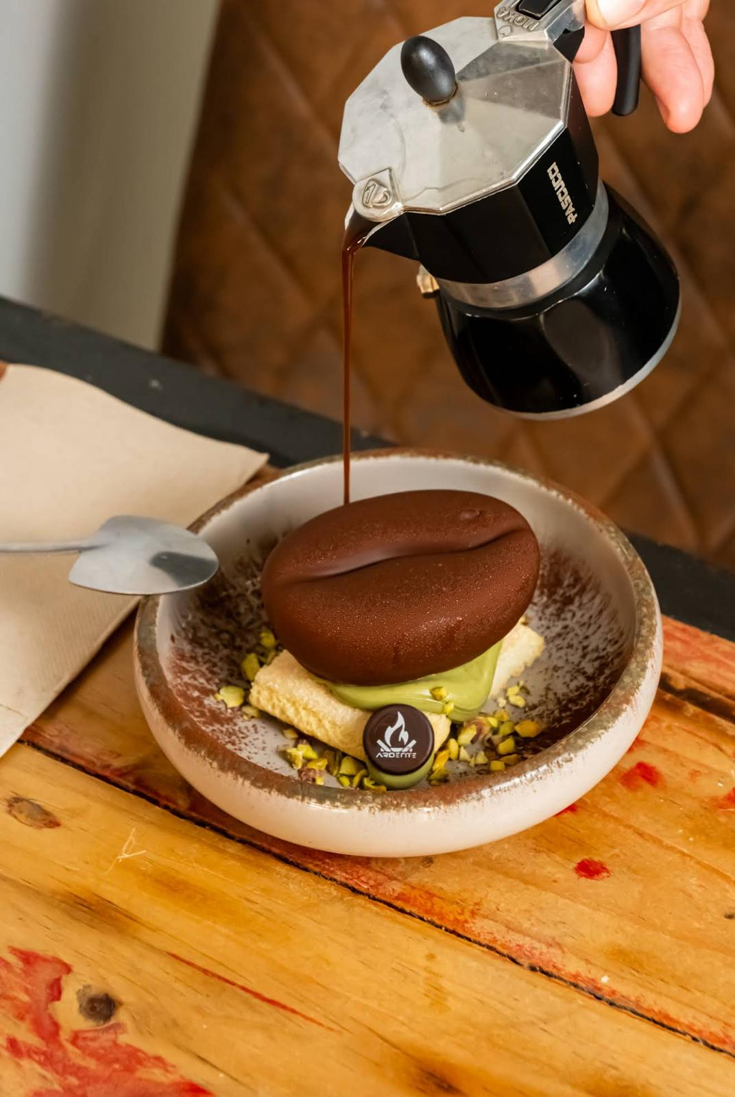 Café servido sobre un postre de pistacho de Ardente